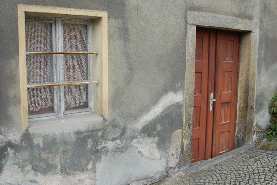Foto 4: Feuchte- und Salzschäden am Außenputz – Bruchsteinmauerwerk ohne Natursteinsockelschwelle